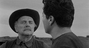 Movie still from “Terror in a Texas Town” (1958), directed by Joseph H. Lewis – An older man and a younger man are talking to each other; Close Up shot, Over the shoulder angle