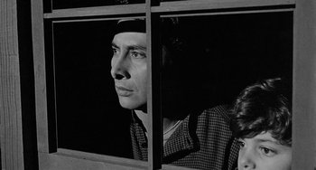 Movie still from “Terror in a Texas Town” (1958), directed by Joseph H. Lewis – A black and white photo of a man looking out of a window; Close Up shot, Low angle