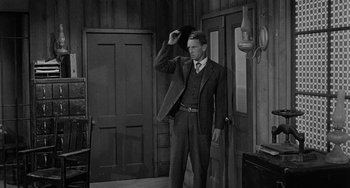 Movie still from “Terror in a Texas Town” (1958), directed by Joseph H. Lewis – A black and white photo of a man in a suit and tie; Medium shot, Low angle