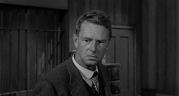Movie still from “Terror in a Texas Town” (1958), directed by Joseph H. Lewis – An older man wearing a suit and a tie; Close Up shot, Over the shoulder angle