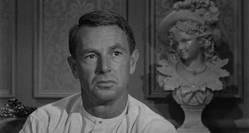 Movie still from “Terror in a Texas Town” (1958), directed by Joseph H. Lewis – Black and white photograph of a man in front of a statue; Close Up shot, Over the shoulder angle