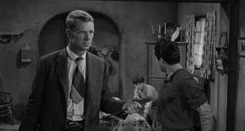 Movie still from “Terror in a Texas Town” (1958), directed by Joseph H. Lewis – A man in a suit and tie is shaking hands with another man in a suit and tie; Medium shot, Over the shoulder angle