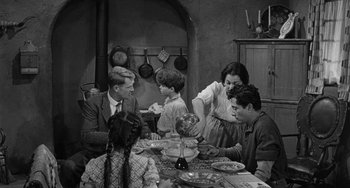 Movie still from “Terror in a Texas Town” (1958), directed by Joseph H. Lewis – An old photo of a family sitting at a dinner table; Wide shot, High angle