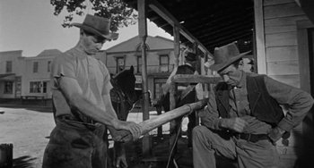 Movie still from “Terror in a Texas Town” (1958), directed by Joseph H. Lewis – Two men in cowboy hats are holding a baseball bat; Medium shot, Low angle