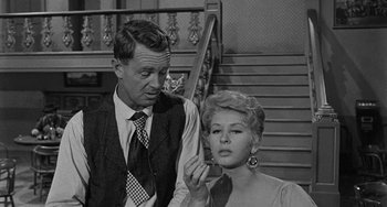Movie still from “Terror in a Texas Town” (1958), directed by Joseph H. Lewis – A man and a woman sitting next to each other on stairs; Medium shot, Over the shoulder angle