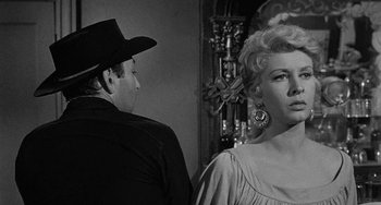 Movie still from “Terror in a Texas Town” (1958), directed by Joseph H. Lewis – A man and a woman standing next to each other in a room; Close Up shot, Low angle