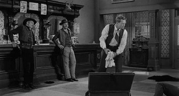 Movie still from “Terror in a Texas Town” (1958), directed by Joseph H. Lewis – Two men in suits and ties in an old - fashioned bar; Wide shot, Over the shoulder angle