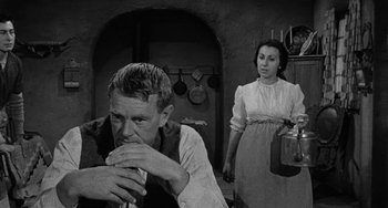 Movie still from “Terror in a Texas Town” (1958), directed by Joseph H. Lewis – A man and a woman are standing in front of a wall; Medium shot, Over the shoulder angle