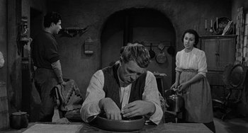 Movie still from “Terror in a Texas Town” (1958), directed by Joseph H. Lewis – A man sitting at a table with a bowl in front of two women; Medium shot, Over the shoulder angle