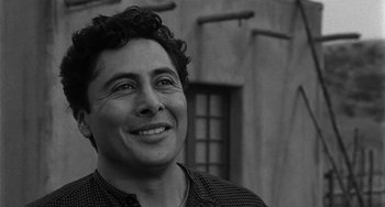 Movie still from “Terror in a Texas Town” (1958), directed by Joseph H. Lewis – Black and white photograph of a man smiling for the camera; Close Up shot, Over the shoulder angle