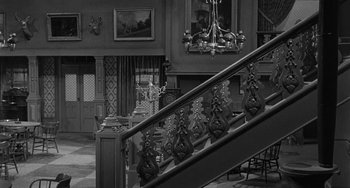 Movie still from “Terror in a Texas Town” (1958), directed by Joseph H. Lewis – A black - and - white photo of a staircase in a house; Wide shot, High angle