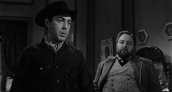 Movie still from “Terror in a Texas Town” (1958), directed by Joseph H. Lewis – A man and a man standing next to each other; Medium shot, Over the shoulder angle