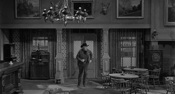 An old photo of a man standing in front of an entrance way