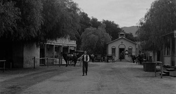 Movie still from “Terror in a Texas Town” (1958), directed by Joseph H. Lewis – An old photo of a man standing in front of a church; Extreme Wide shot, High angle