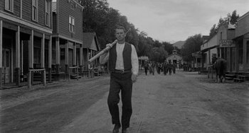 Movie still from “Terror in a Texas Town” (1958), directed by Joseph H. Lewis – A black and white photo of a man holding a baseball bat; Wide shot, Low angle