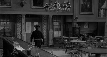 Movie still from “Terror in a Texas Town” (1958), directed by Joseph H. Lewis – A black and white photo of a man walking in a restaurant; Wide shot, High angle