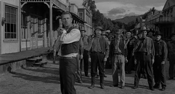Movie still from “Terror in a Texas Town” (1958), directed by Joseph H. Lewis – A group of men standing on a street in front of a building; Medium shot, Low angle