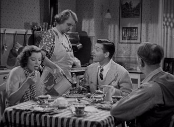 Movie still from “Test Pilot” (1938), directed by Victor Fleming – An old photo of a woman pouring a cup of tea to a man; Medium shot, High angle