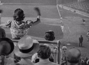 Movie still from “Test Pilot” (1938), directed by Victor Fleming – An old photo of a woman holding a baseball bat; Extreme Wide shot, High angle