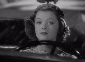 Movie still from “Test Pilot” (1938), directed by Victor Fleming – A black - and - white photo of a woman driving a car; Close Up shot, Over the shoulder angle