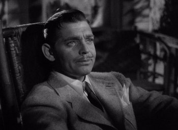 Movie still from “Test Pilot” (1938), directed by Victor Fleming – A man in a suit and tie sitting in a chair; Close Up shot, High angle