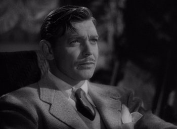 Movie still from “Test Pilot” (1938), directed by Victor Fleming – A man in a suit and tie sitting down; Close Up shot, High angle