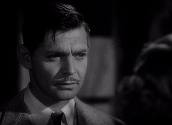 Movie still from “Test Pilot” (1938), directed by Victor Fleming – A black and white photo of a man in a suit and tie; Close Up shot, Over the shoulder angle