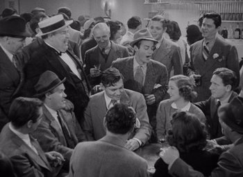 Movie still from “Test Pilot” (1938), directed by Victor Fleming – A group of men and women gathered around a table; Wide shot, High angle
