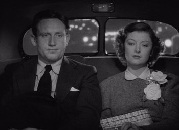 Movie still from “Test Pilot” (1938), directed by Victor Fleming – A man and a woman sitting in the back of a car; Medium shot, High angle