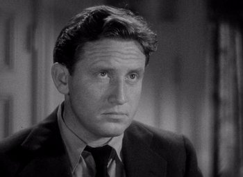 Movie still from “Test Pilot” (1938), directed by Victor Fleming – A man wearing a suit and tie in a black and white photo; Close Up shot, High angle