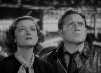 Movie still from “Test Pilot” (1938), directed by Victor Fleming – A black and white photo of a man and a woman looking up; Close Up shot, Low angle