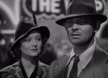 Movie still from “Test Pilot” (1938), directed by Victor Fleming – A black and white photo of a man and a woman wearing hats; Close Up shot, High angle