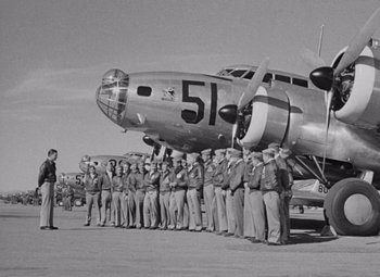 Movie still from “Test Pilot” (1938), directed by Victor Fleming – A group of men standing in front of an airplane; Wide shot, Low angle