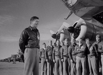 Movie still from “Test Pilot” (1938), directed by Victor Fleming – An older man standing in front of a group of men; Medium shot, Low angle