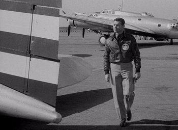Movie still from “Test Pilot” (1938), directed by Victor Fleming – A man walking next to an airplane on a runway; Medium shot, Low angle
