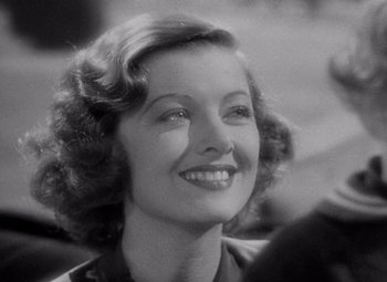 Movie still from “Test Pilot” (1938), directed by Victor Fleming – An old photo of a woman smiling for the camera; Close Up shot, Over the shoulder angle