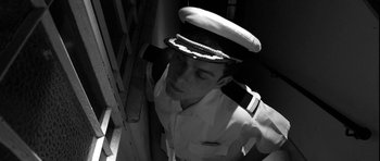 Movie still from “Tetro” (2009), directed by Francis Ford Coppola – Black and white photograph of a man in a naval uniform; Medium shot, High angle