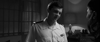 Movie still from “Tetro” (2009), directed by Francis Ford Coppola – A man in a uniform smiling for the camera; Medium shot, Low angle