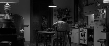 Movie still from “Tetro” (2009), directed by Francis Ford Coppola – A man sitting at a table in a kitchen; Wide shot, Over the shoulder angle