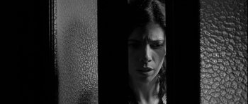 Movie still from “Tetro” (2009), directed by Francis Ford Coppola – A black - and - white photo of a woman looking at the camera; Close Up shot, Low angle