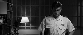 Movie still from “Tetro” (2009), directed by Francis Ford Coppola – A man in uniform standing next to a lamp; Medium shot, Low angle