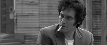 Movie still from “Tetro” (2009), directed by Francis Ford Coppola – Black and white photograph of a man smoking a cigarette; Close Up shot, Low angle