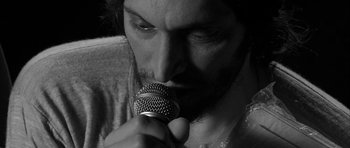 Movie still from “Tetro” (2009), directed by Francis Ford Coppola – A person holding a microphone; Extreme Close Up shot, Low angle