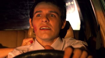 Movie still from “Tetro” (2009), directed by Francis Ford Coppola – A young man driving a car at night with his mouth wide open; Close Up shot, Over the shoulder angle