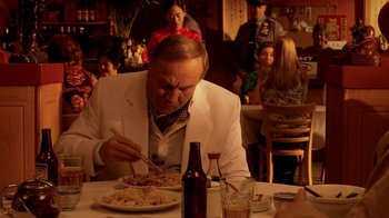 Movie still from “Tetro” (2009), directed by Francis Ford Coppola – A man sitting at a table eating a plate of food; Medium shot, Over the shoulder angle