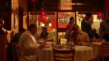 Movie still from “Tetro” (2009), directed by Francis Ford Coppola – A group of people sitting at a table in front of a window; Wide shot, High angle