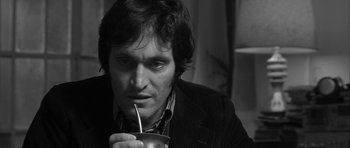 Movie still from “Tetro” (2009), directed by Francis Ford Coppola – A black and white photo of a man drinking a drink; Close Up shot, High angle