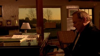 Movie still from “Tetro” (2009), directed by Francis Ford Coppola – A man sitting at a table in front of an open window; Medium shot, High angle