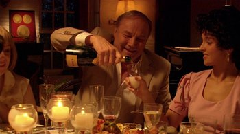 Movie still from “Tetro” (2009), directed by Francis Ford Coppola – A man pouring wine into a glass at a dinner table; Medium shot, High angle