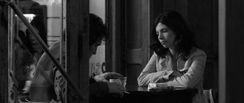 Movie still from “Tetro” (2009), directed by Francis Ford Coppola – A man and a woman sitting at a table; Medium shot, Over the shoulder angle